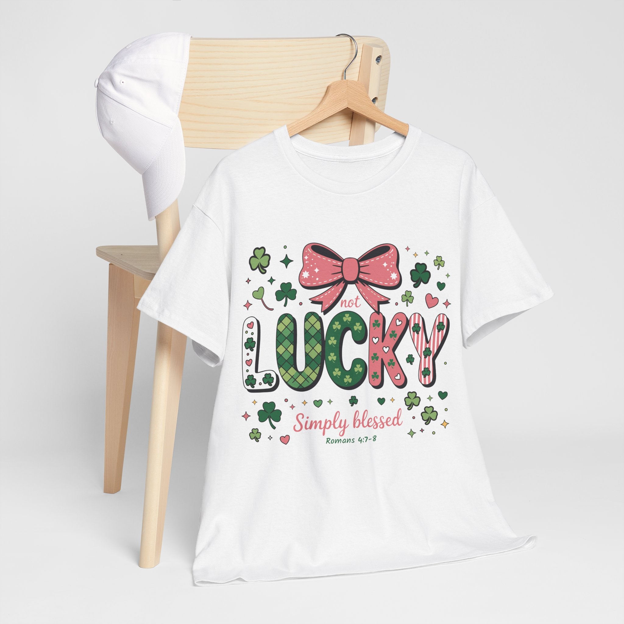 Simply Blessed Tee — “Not Lucky, Simply Blessed” with Pastel Bow, Clovers & Romans 4:7-8 Unisex Cotton Tee