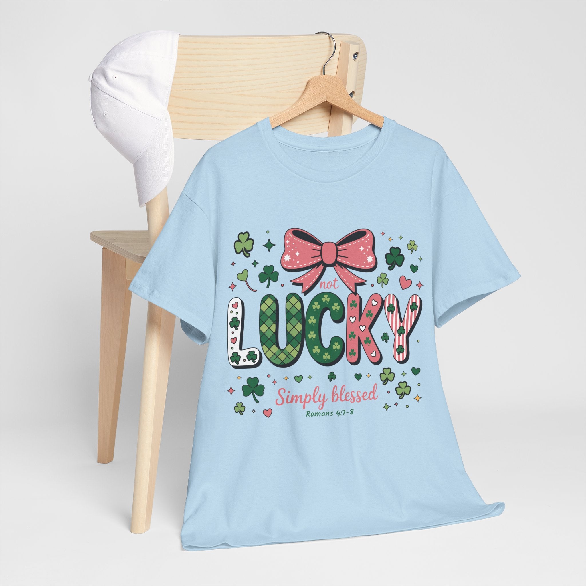 Simply Blessed Tee — “Not Lucky, Simply Blessed” with Pastel Bow, Clovers & Romans 4:7-8 Unisex Cotton Tee